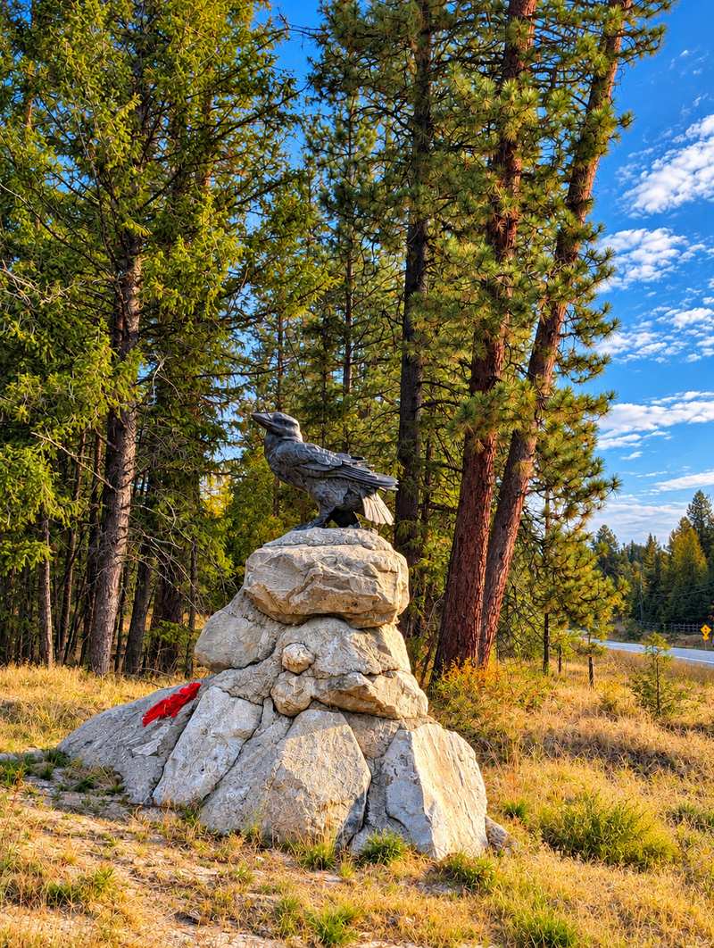 Raven statue perched on a stacked-rock pile in front of Raven Hill Rd, Anarchist Mountain, Osoyoos BC